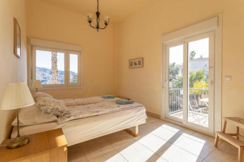 Un dormitorio con una cama y una ventana grande. en Villa Fuentes, en Almuñécar