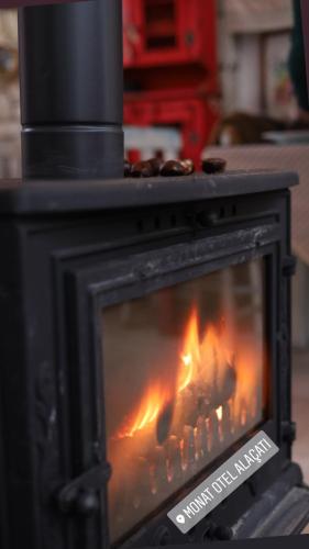 a stove with a fire inside of it at Monat Otel Alaçatı in Alaçatı