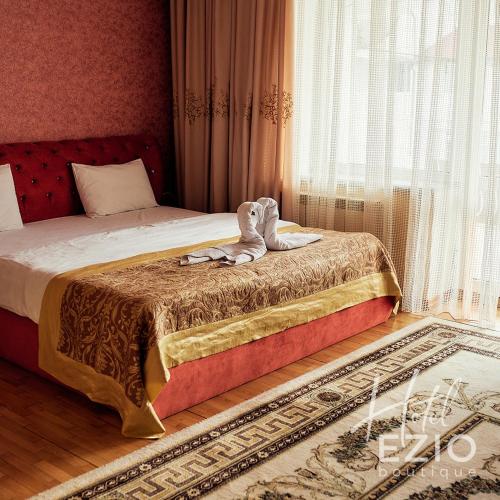 a bedroom with a bed and a window at Hotel EZIO in Chişinău