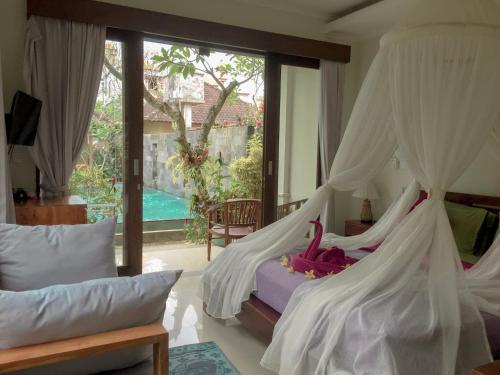 a bedroom with a bed with a mosquito net at Merthayasa Bungalow 2 in Ubud