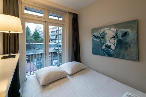 una camera con un letto e una foto di una mucca di Two-bedroom Apartment in Amsterdam West ad Amsterdam