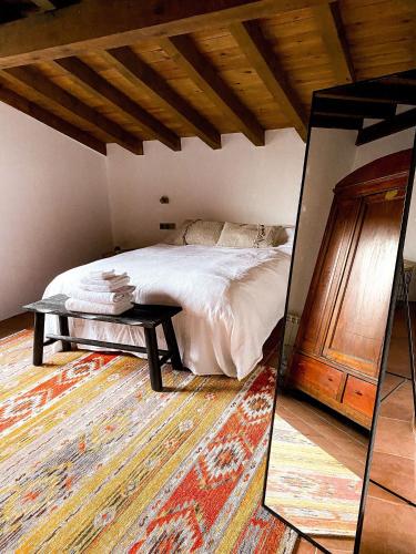a bedroom with a bed with a table and a mirror at EL CUENTO DE LA ENCINA. Un espacio para sentir in Majaelrayo