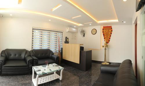 a waiting room with couches and a table at Thenmala Hormuz Inn in Kolattupuzha