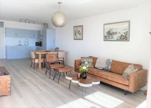 een woonkamer met een bank en een tafel bij Witte Jade in Egmond aan den Hoef