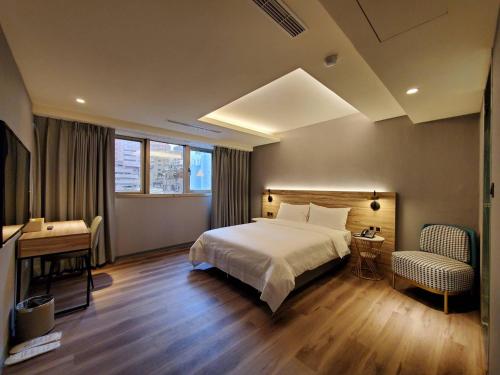 1 dormitorio con cama, mesa y escritorio en HINOEN Hotel, en Taipéi