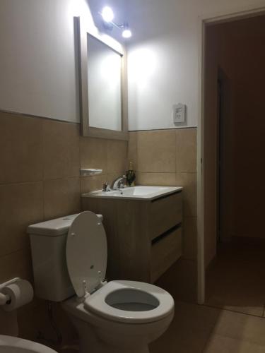 a bathroom with a toilet and a sink and a mirror at Centro Peru in Paraná