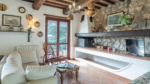 a living room with a large stone fireplace at Villa Paola 6, Emma Villas in Gualdo Cattaneo