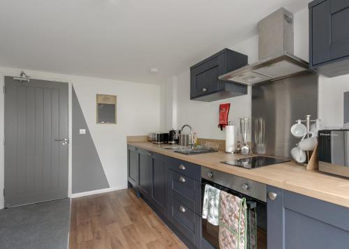a kitchen with blue cabinets and a counter top at Donington Cottage Apt 7 in Castle Donington