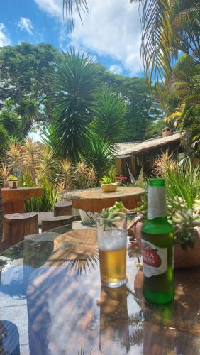 a bottle of beer sitting on a table with a glass at 3 Palmeiras Guest Lounge in Miguel Pereira