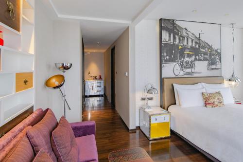 a hotel room with a bed and a couch at Hotel Indigo Bangkok Wireless Road by IHG in Bangkok