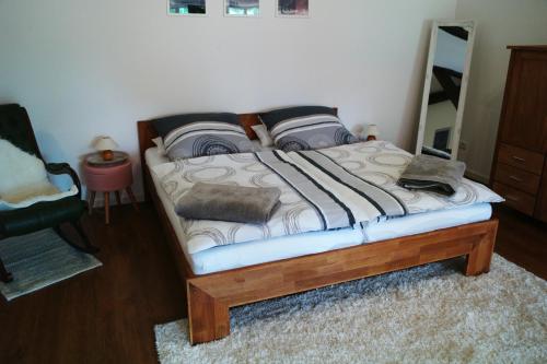een slaapkamer met een bed met een houten frame en een spiegel bij Schäfchenwolke in Worpswede