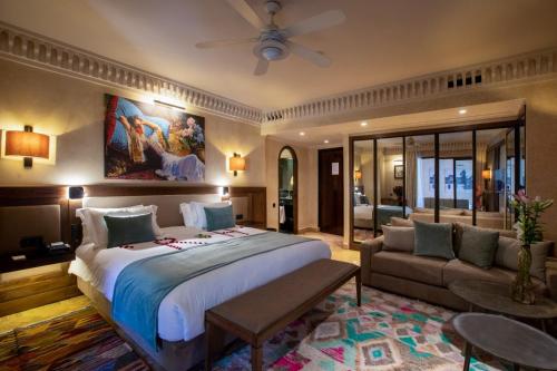 a bedroom with a large bed and a couch at Les Jardins De La Koutoubia in Marrakech