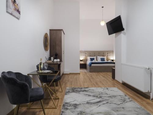 a living room with a bed and a table and chairs at ELISABETH HOME Piata Mare in Sibiu