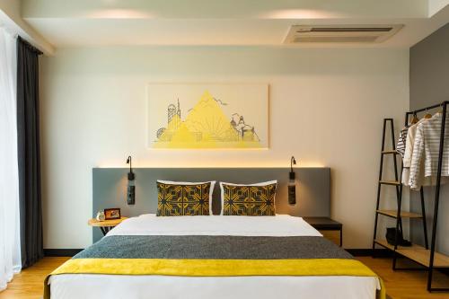 提比里斯的住宿－Citadines City Centre Tbilisi Apart`hotel，一间卧室配有一张黄色和黑色毯子的床