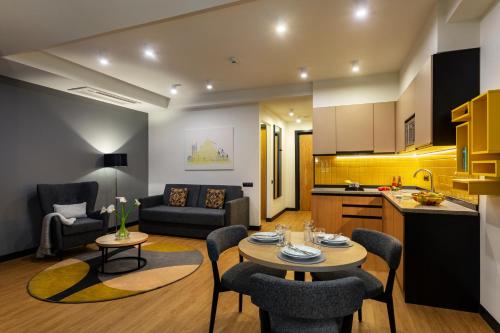 a kitchen and a living room with a table and chairs at Citadines City Centre Tbilisi Apart`hotel in Tbilisi City