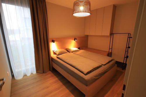 a bedroom with a bed and a large window at Apartmán Victory Port in Liptovský Mikuláš