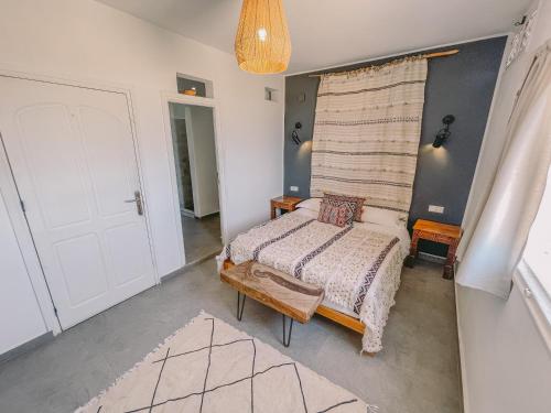 a bedroom with a bed and a white door at Blue Waves Surf House in Agadir