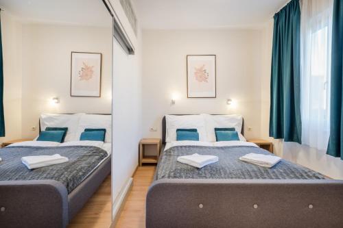 two beds in a room with blue pillows at BpR Blue Paradise Apartment with A/C in Budapest