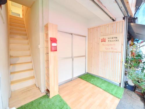 a room with a staircase and green grass at Harimayabashi Guesthouse in Kochi