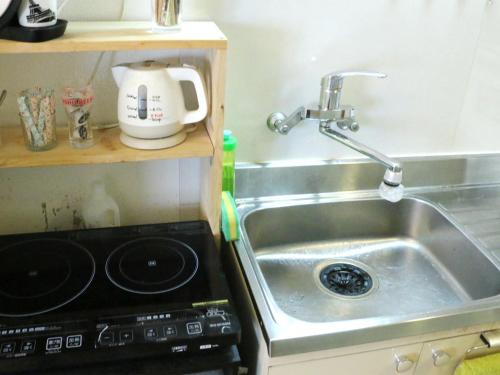a kitchen sink with a mixer next to it at Harimayabashi Guesthouse in Kochi