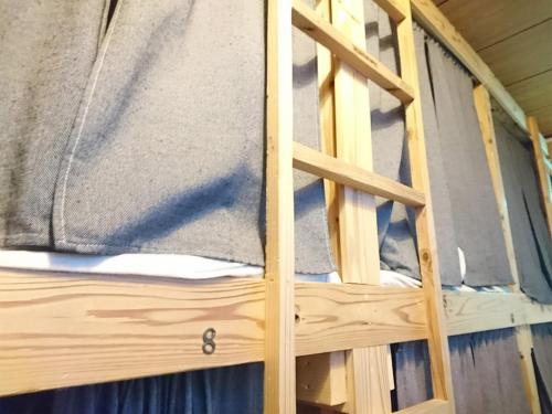 ein Etagenbett aus Holz mit einer Leiter darauf in der Unterkunft Harimayabashi Guesthouse in Kōchi