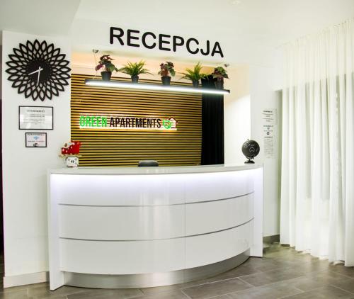 a reception desk with a sign on a wall at Zielone Apartamenty Katowice Chorzów in Chorzów
