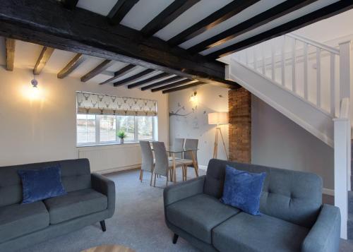 a living room with two couches and a table at Donington Cottage Apt 8 in Castle Donington