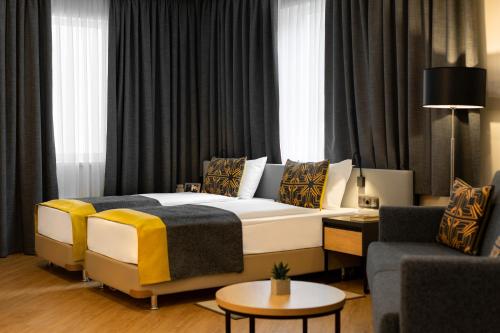 a bedroom with a king sized bed and a couch at Citadines City Centre Tbilisi Apart`hotel in Tbilisi City