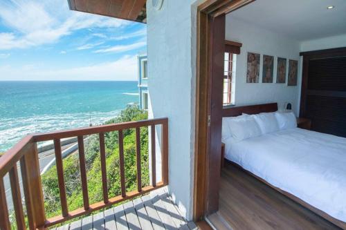 a bedroom with a bed and a balcony with the ocean at Bantry Bay Home with Atlantic Ocean Views in Cape Town
