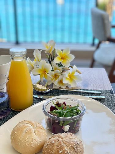 a table with a plate of food and a bowl of flowers at Castello Infinity Suites - Adults Only in Agia Pelagia