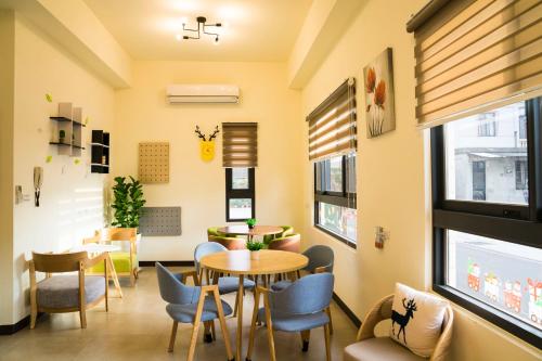 - une salle d'attente avec des tables, des chaises et des fenêtres dans l'établissement Ba Ba Xiao Wu 2, à Jinning