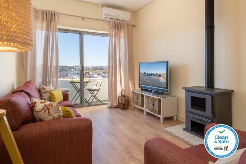 a living room with a couch and a tv and a fireplace at Gaya Avenue Flats - Elegant Contemporary Flats with Balcony in Vila Nova de Gaia