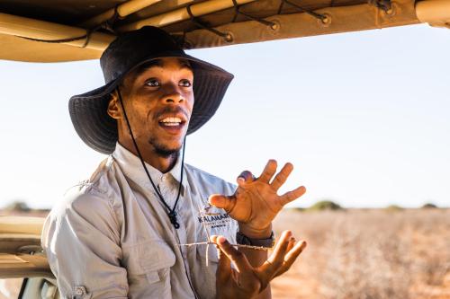 a man wearing a hat standing in the back of a vehicle at Gondwana Kalahari Anib Lodge in Hardap