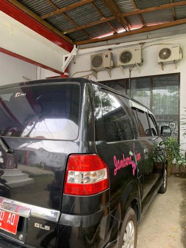 a black van is parked in a garage at Jambura Inn in Gorontalo