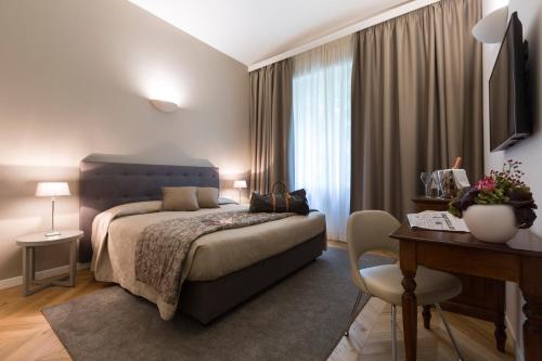 um quarto com uma cama, uma mesa e uma secretária em Villaggio Narrante - Foresteria delle Vigne em Serralunga d'Alba