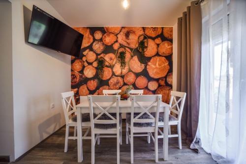 a dining room with a table and a wall of logs at Vila Čarna Zlatibor in Zlatibor