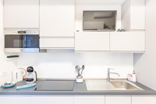 a white kitchen with white cabinets and a sink at La Perla del Mare, Terre Marine in Monterosso al Mare