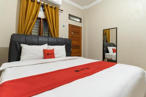 ein Schlafzimmer mit einem Bett mit einer roten Decke darauf in der Unterkunft RedDoorz At Joyce Guest House Medan in Medan