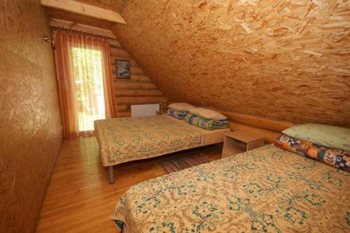 a room with two beds in a log cabin at Likimo ratas in Paliepis