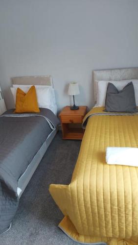 a bedroom with two beds and a table with a lamp at White Shelf West Dartford in Kent
