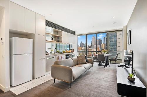 a kitchen and living room with a couch and a table at Southbank Apartments Freshwater Place in Melbourne