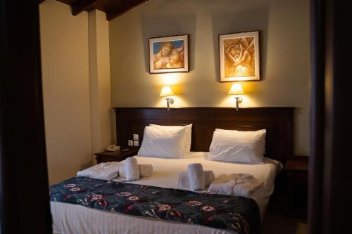 a hotel room with a bed with two towels on it at Hotel Antoniadis in Kalabaka