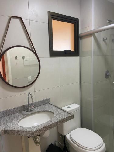 a bathroom with a sink and a mirror and a toilet at Vg Sun cumbuco 310 c4 in Cumbuco