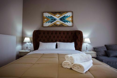 a bedroom with a large bed with towels on it at Δωμάτια με θέα in Méga Khoríon