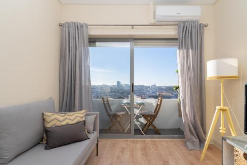 a living room with a couch and a large window at Gaya Avenue Flats - Elegant Contemporary Flats with Balcony in Vila Nova de Gaia