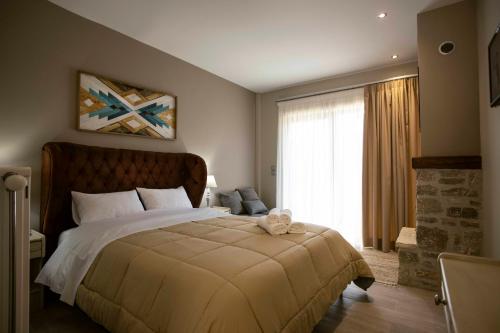 1 dormitorio con cama grande y ventana grande en Δωμάτια με θέα, en Méga Khoríon