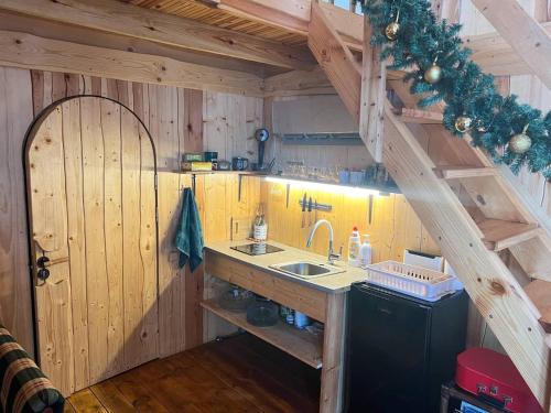 a kitchen with a sink and a staircase with christmas decorations at Dragon house in the tree! Jacuzzi, Sauna ,Cinema,Heated in Līči