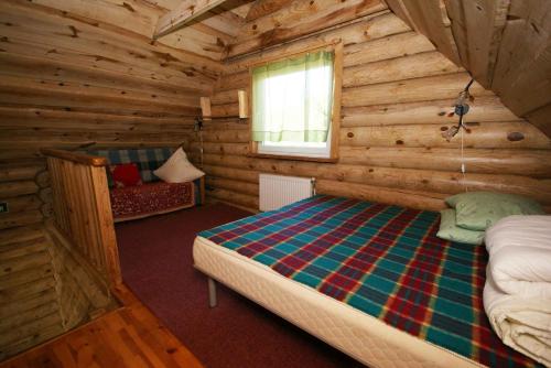 a bedroom with a bed in a log cabin at Likimo ratas in Paliepis