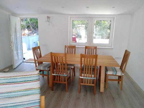 a dining room with a wooden table and chairs at Apartments Bezek in Trstenik