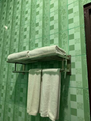 a towel rack with three towels in a bathroom at Jambura Inn in Gorontalo
